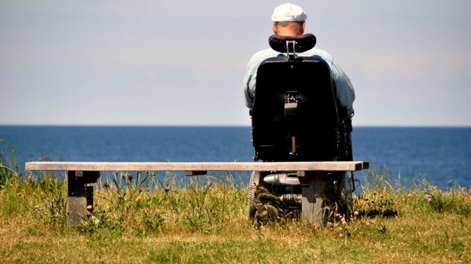 Foto von Palle Knudsen man in black jacket and white helmet standing on green grass field near body of water