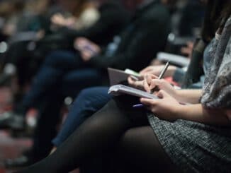 Piratenpartei Deutschland - selective focus photography of people sitting on chairs while writing on notebooks