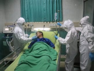 man in white scrub suit lying on hospital bed