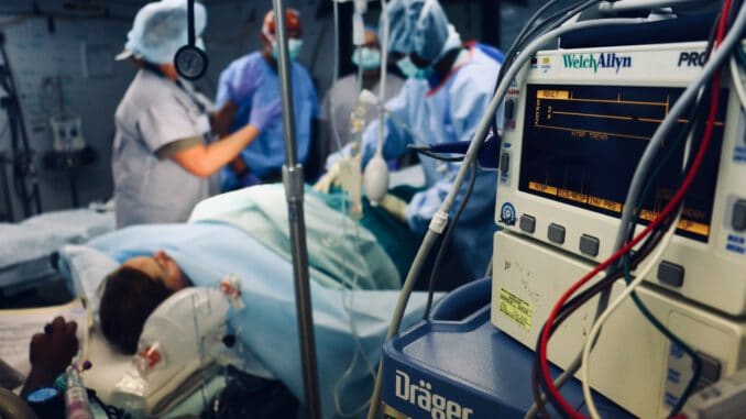 group of people doing a surgery on a person inside the operating room