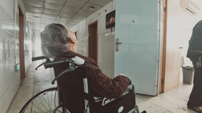 woman in black and white long sleeve shirt sitting on black wheelchair