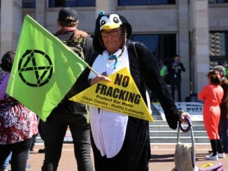 man in black leather jacket holding green banner