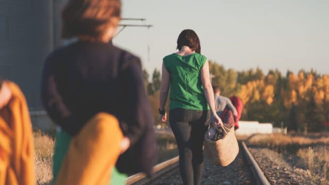 Foto von Priscilla Du Preez group of people walking on train tracks during sunrise