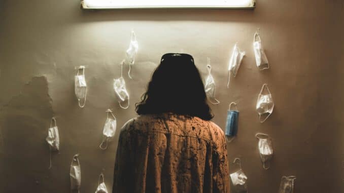 Foto von Parastoo Maleki woman in brown and black coat standing in front of white wall