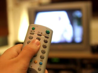 Fernsehzuschauer mit einer Fernbedienung, über dts Nachrichtenagentur