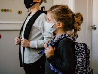 woman in black long sleeve shirt holding white face mask