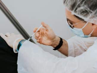 person in white long sleeve shirt holding gray pen